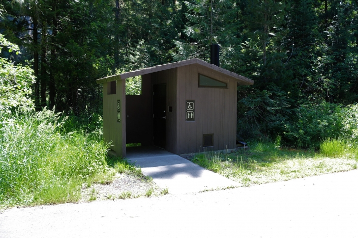 A picture of a second vault style outhouse in Giant White Pine Campground. It is located midway down the campground.